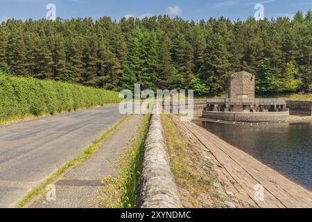 The road along the Errwood Reservoir with the spillway in the background, near Buxton in the East Midlands, Derbyshire, Peak District, England, UK Stock Photo