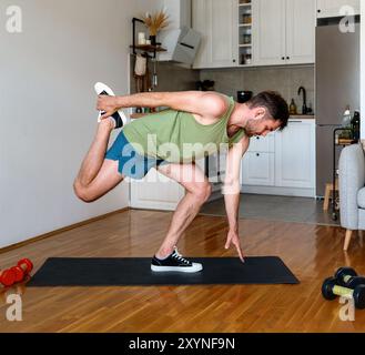 Male athlete doing fitness stretching exercise at home. Home workout real life. Stock Photo