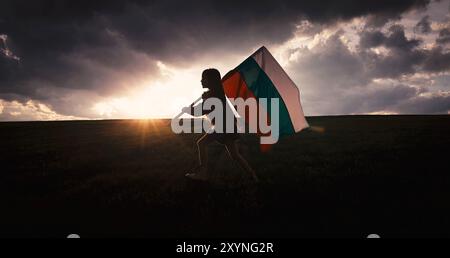 Woman in ethnic folklore costume waving Bulgarian flag on a sunset green field celebrating independence and liberation Stock Photo