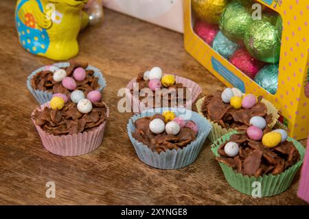 A selection of Easter Chocolate nest Cakes topped with little chocolate mini eggs on a wooden table Stock Photo
