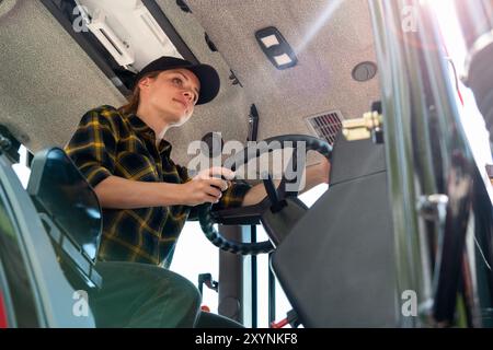 Woman working on a farm as a tractor driver Stock Photo