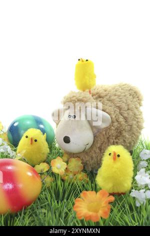 Easter lamb with chicks and Easter eggs in a flower meadow Stock Photo