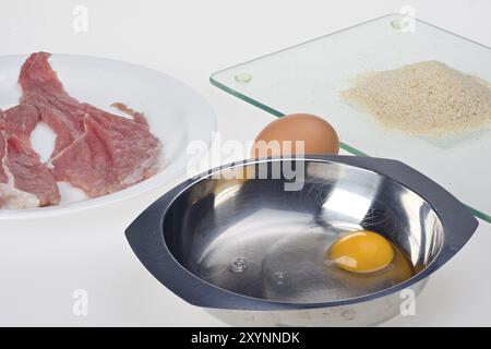 Making a viennese schnitzel isolated on white Stock Photo