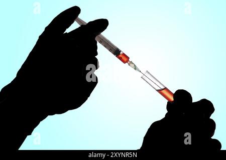 Hand holding a syringe and taking a blood sample from a tube for analysis Stock Photo
