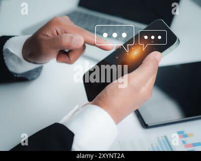 Human hand using smartphone typing, Chatting conversation in chat box icons pop up, Social media marketing concept, Chatting on application communicat Stock Photo