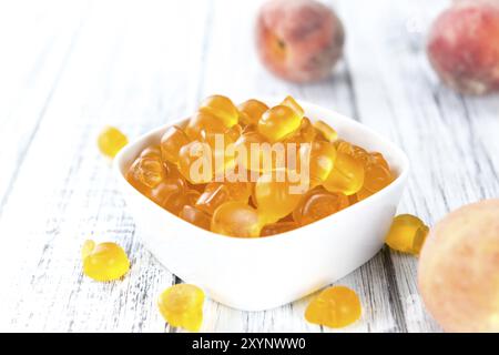 Heap of gummy Peaches on wooden background (close-up shot) Stock Photo