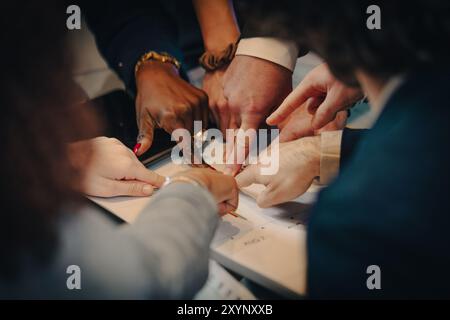 Business team is analyzing data and brainstorming, pointing at a financial chart on a table Stock Photo