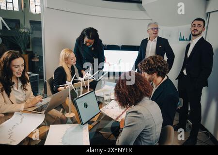 Business team is working together, analyzing data and discussing about green energy investments Stock Photo
