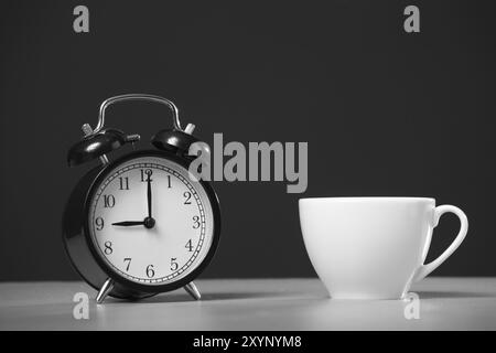 Cup of coffee and alarm clock on a black background Stock Photo