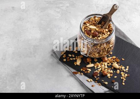 Homemade healthy granola made of oats nuts and fruits on black stone background copy space Stock Photo