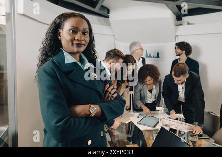 Diverse team of engineers and managers are discussing about a blueprint of a wind farm project Stock Photo