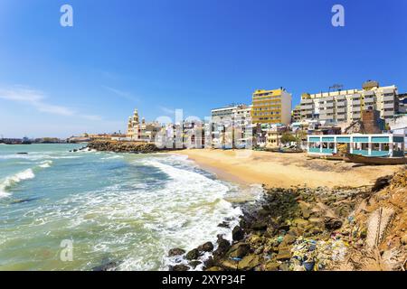 Kanyakumari, India, February 22, 2015: Colorful houses and large concrete hotels line a small beach near St Arokiyanathar Alayam Church at the souther Stock Photo