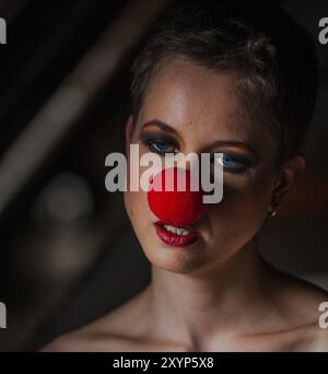 Woman wears a red clown nose Stock Photo