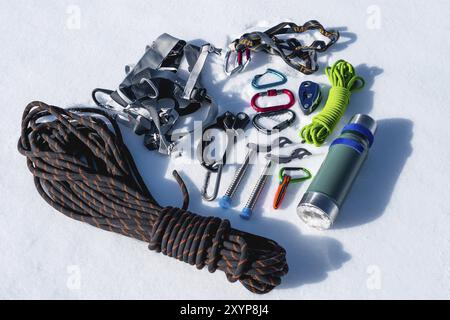 Close-up of winter climbing equipment on fresh snow on a sunny day. Carbines with a rope gazebo and zhumar as well as other adaptations when practicin Stock Photo