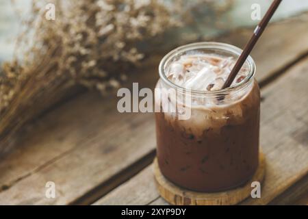 Tasty iced chocolate milk cocoa in a glass on vintage wooden background, selective focus Stock Photo