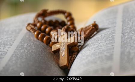 Dark brown wooden cross on an old open book symbolizing the spread of Jesus Christs love among Christians reflecting faith devotion and the importance Stock Photo