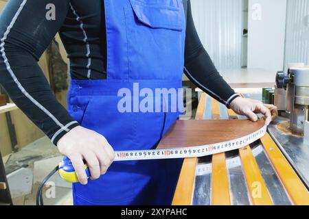 Closeup of Carpenter's hands using one meter in a cottage workshop Stock Photo