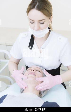 A close-up of the cleaning procedure in the office of cosmetology. Cleaning of the skin with foam. Beautiful girl in beauty salon on facial cleansing Stock Photo