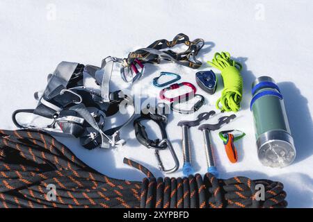 Close-up of winter climbing equipment on fresh snow on a sunny day. Carbines with a rope gazebo and zhumar as well as other adaptations when practicin Stock Photo