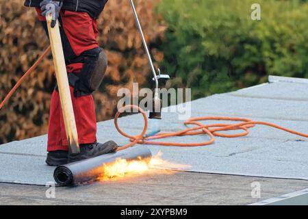 Roofer lays roofing felt Stock Photo