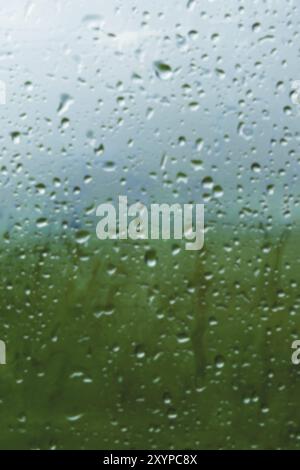 Natural background Drops on both sides of the glass from the rain and from the fogging abstract view, raindrops against the blue glass and the blurred Stock Photo
