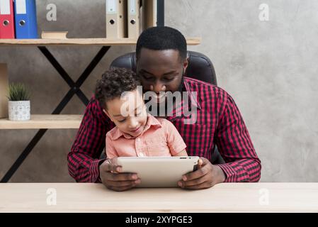 Black father son using tablet table Stock Photo