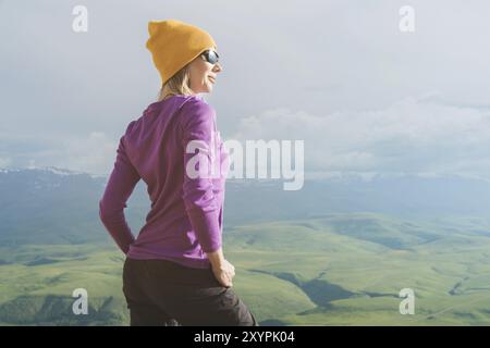 A hipster girl in a straw hat and glasses on the nature landscape Stock Photo