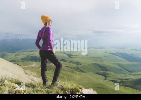 A hipster girl in a straw hat and glasses on the nature landscape Stock Photo