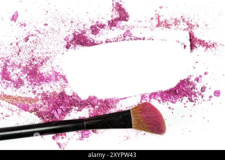 Traces of vibrant pink blush and eye shadow, forming a frame, with a makeup brush. A design template for a makeup artist's business card or flyer desi Stock Photo