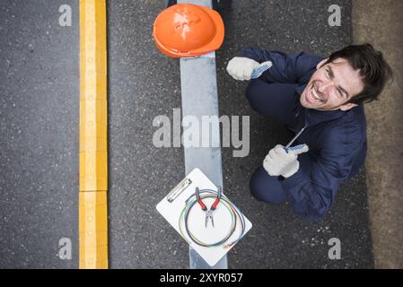 high angle view happy male electrician showing thumb up workplace Stock Photo