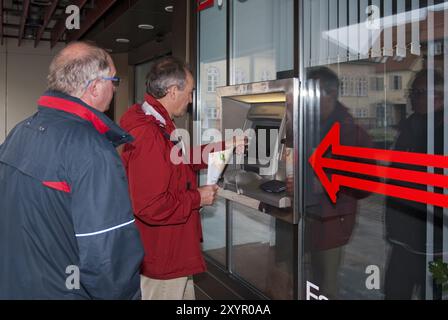 2 men standing at an ATM Stock Photo