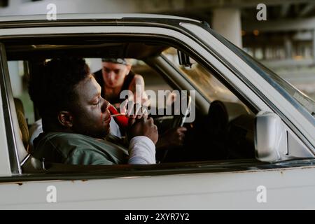 Side view hot of man sitting in car and lighting cigarette Stock Photo