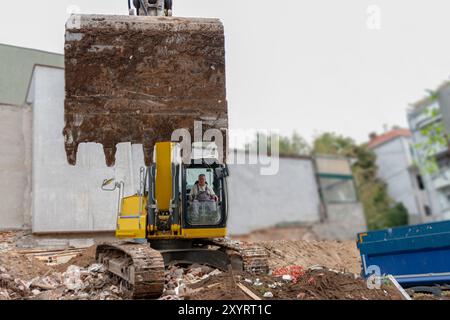 Process of demolition of old building dismantling. Excavator breaking house. Destruction of dilapidated housing for new development Stock Photo