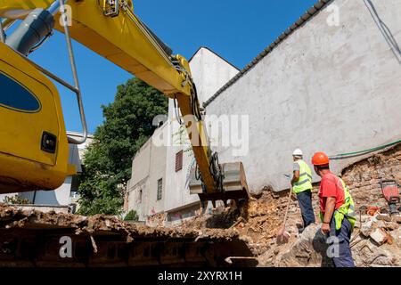 Site manager   standing at the construction site of a private property, supervising, inspecting or overseeing the work progress.Process of demolition Stock Photo