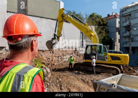 Site manager   standing at the construction site of a private property, supervising, inspecting or overseeing the work progress.Process of demolition Stock Photo