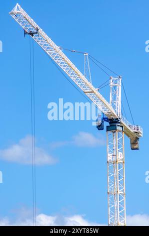 White Tower Crane With A Clear Blue Sky On A Construction Site Stock Photo