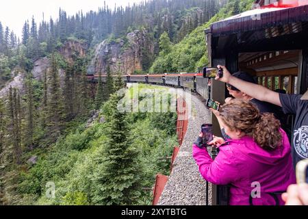 Tourists taking cell phone pictures on the White Pass & Yukon Route Railway Train - Skagway, Alaska, USA Stock Photo