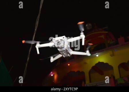 Modern Drone in Flight, Flying in the dark, on black background, View on drones gimbal Night Time Low Light Scenery, Aerial Technologies. Stock Photo