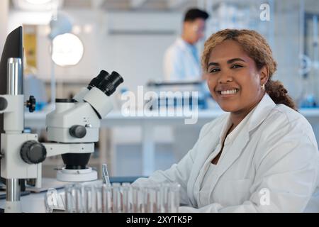 Portrait, happy and woman in laboratory for science, healthcare or biotechnology at microscope. Medical engineer, smile or tech in research facility Stock Photo