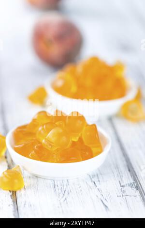Heap of gummy Peaches on wooden background (close-up shot) Stock Photo