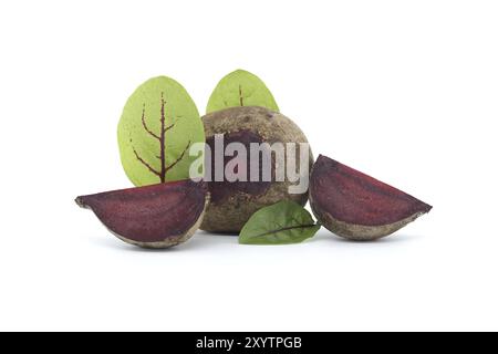 Slices of beetroot, revealing their vibrant purple interiors, are neatly arranged beside whole beetroot vegetables, complete with their fresh green le Stock Photo