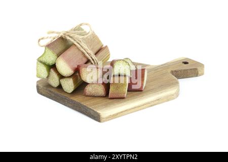 Variety of rhubarb stalks of varying colors from pale green to deep red on wooden cutting board isolated on white background Stock Photo