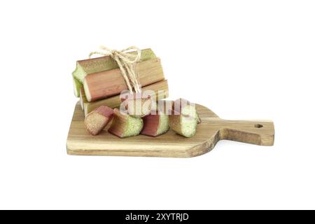 Variety of rhubarb stalks of varying colors from pale green to deep red on wooden cutting board isolated on white background Stock Photo