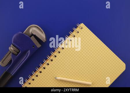 Renovation, building, manufacturing, production or repairs flat lay concept with an arrangement of two assorted wrenches, pencil and note book Stock Photo