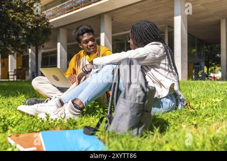 Side view of two male and female african students using laptop studying together in the campus Stock Photo