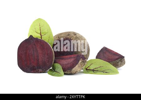 Slices of beetroot showing their purple interior arranged next to whole beetroots vegetables with their green leaves still attached isolated on white Stock Photo