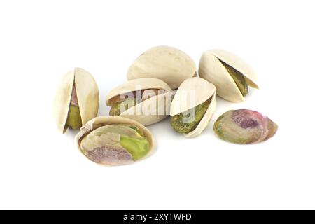 Pistachios in-shell and others peeled exposing the green nuts inside isolated on white background Stock Photo