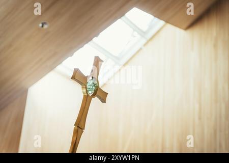 Beautiful golden metal crucifix in church, incidence of light in the background Stock Photo