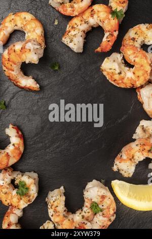 Fried shrimps with lemon, shot from the top on a black background, forming a frame for copyspace Stock Photo