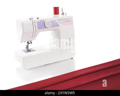 Sewing machine and red fabric isolated on white background Stock Photo